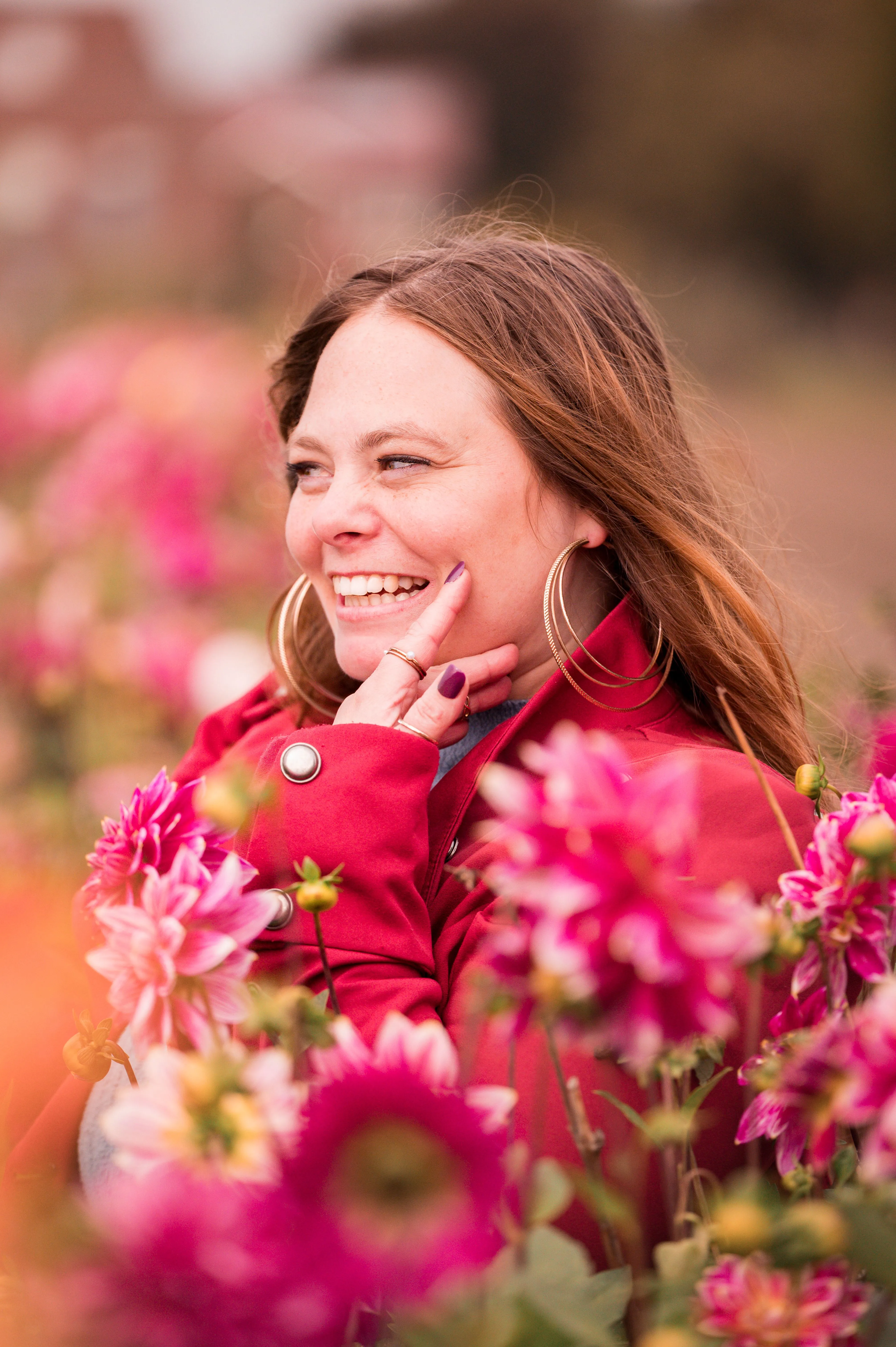 Maike Christof lachend zwischen pinken Blumen